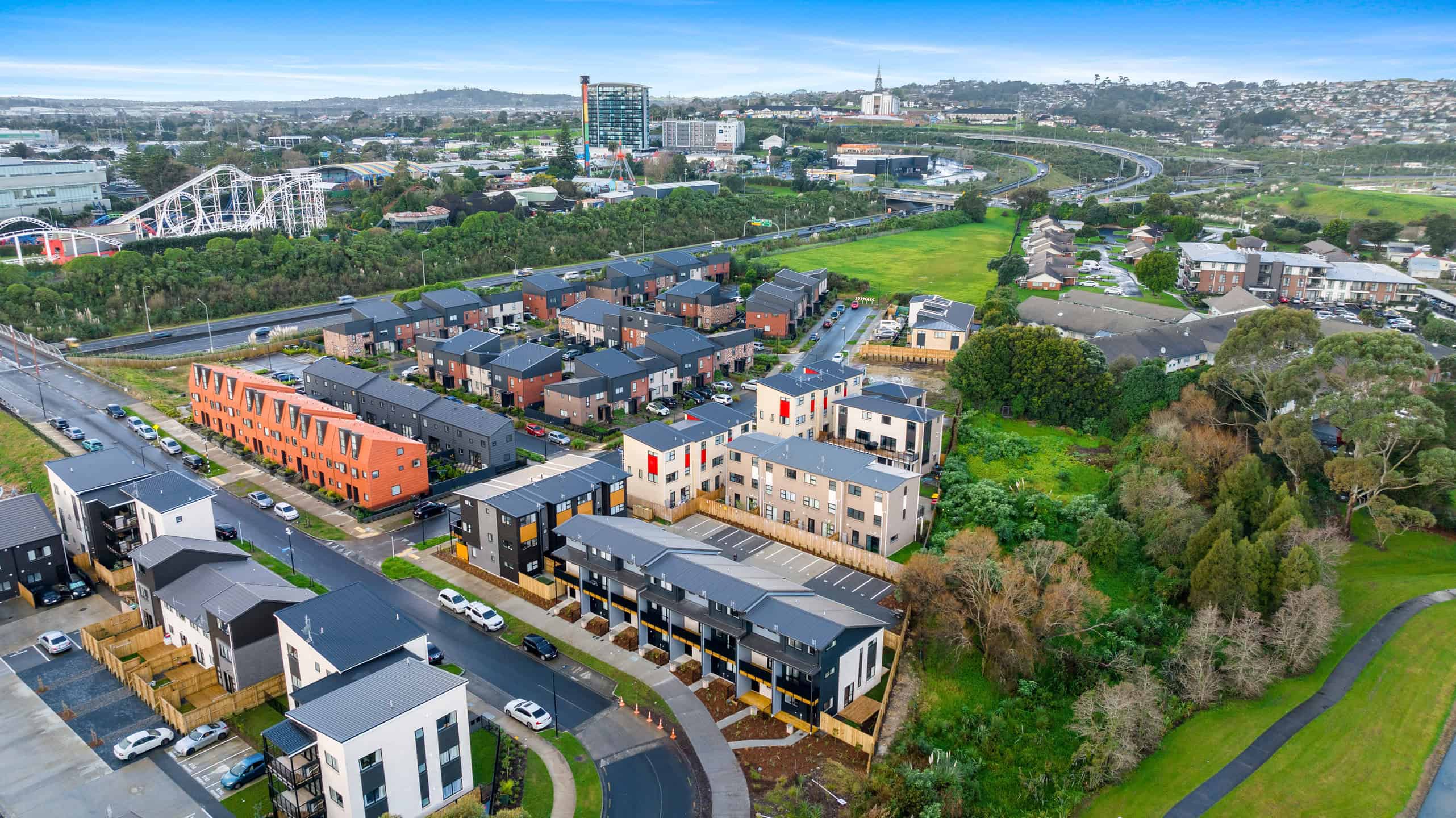 Aerial view of Puhinui Park homes beside green space, with Manukau beyond