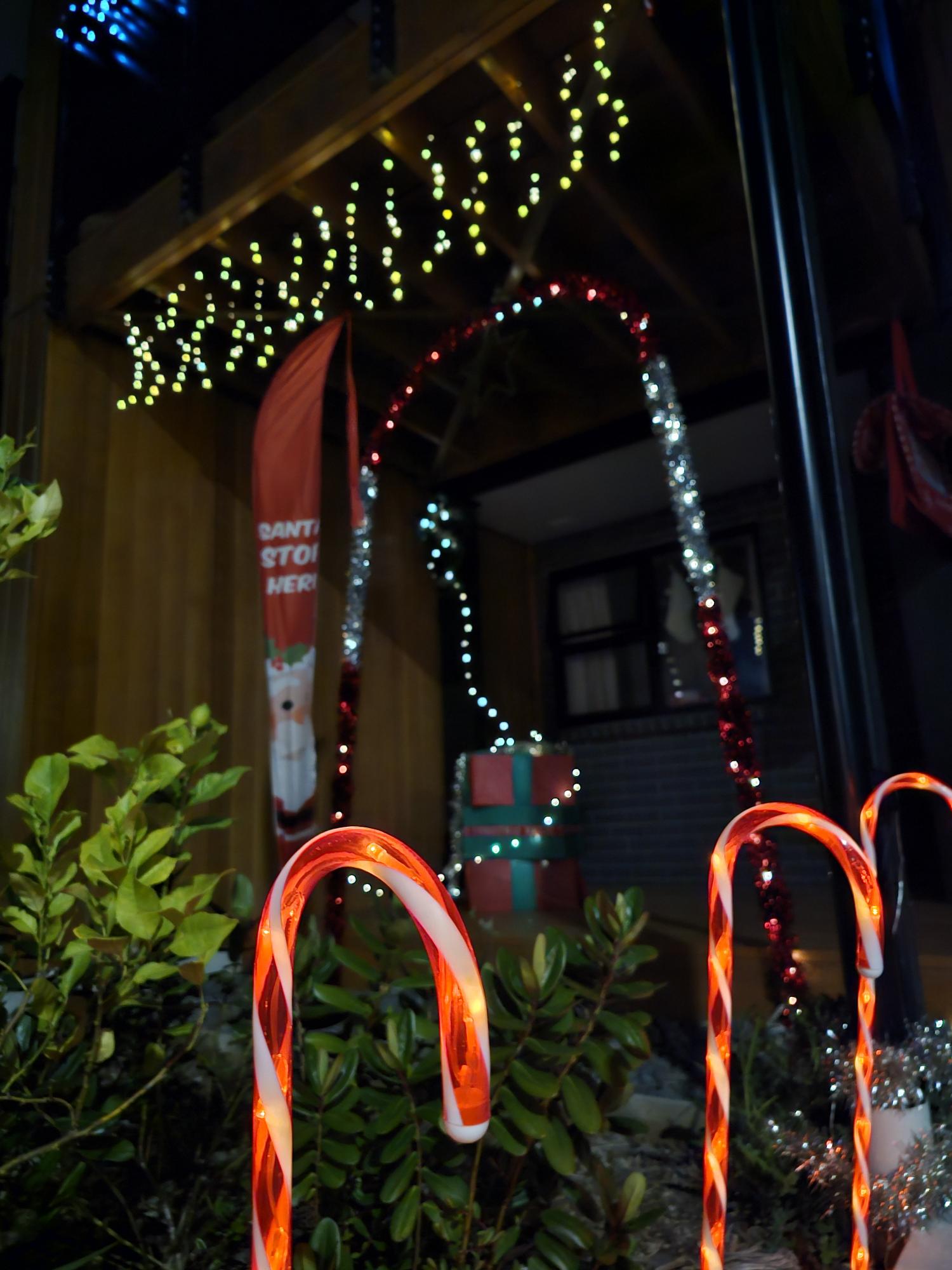 Candy cane lights and Christmas decorations at a front door