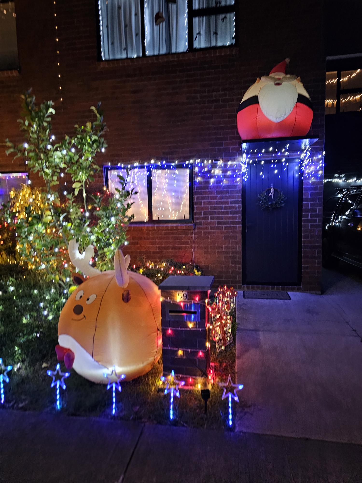A home decorated with Santa, a reindeer and sparkling lights